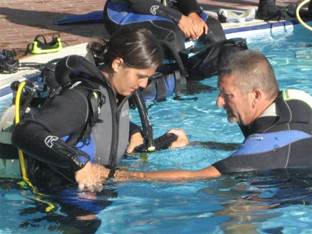 Gli improvvisati subacquei tutti scafandrati nelle loro mute si preparano all'immersione in piscina.